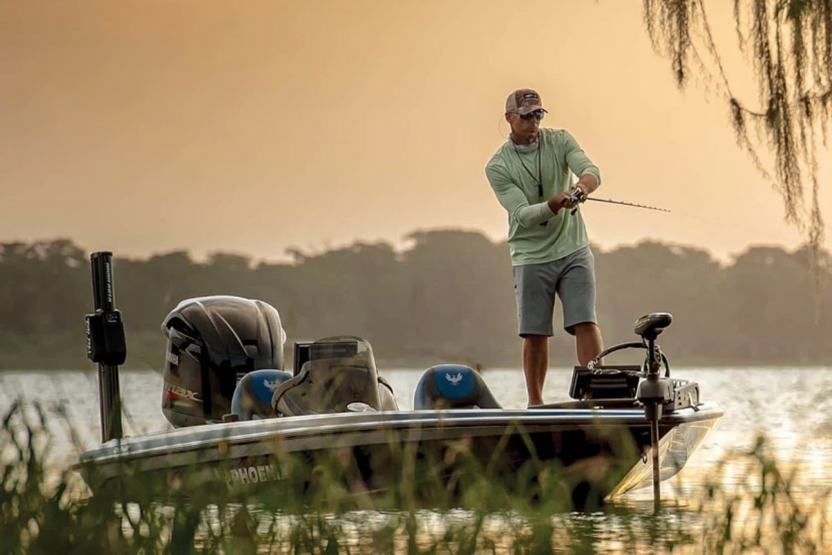 Best trolling motor for bass boat with an angler casting from a modern bass boat on calm water at sunrise.
